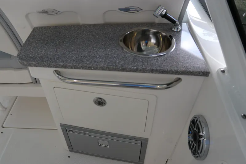 Slide: The Image of 2025 Chaparral 280 OSX boat interior with sink and storage area. - 23