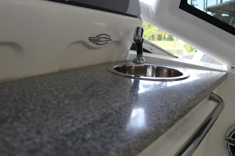 Slide: The Image of 2025 Chaparral 280 OSX boat interior with sleek countertop and built-in sink. - 25