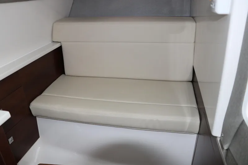 Slide: The Image of 2025 Chaparral 280 OSX interior seating with beige upholstery and wooden accents. - 39