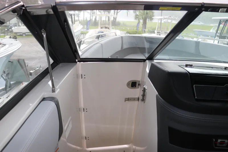Slide: The Image of 2025 Chaparral 280 OSX boat interior with open cabin door and windshield. - 40