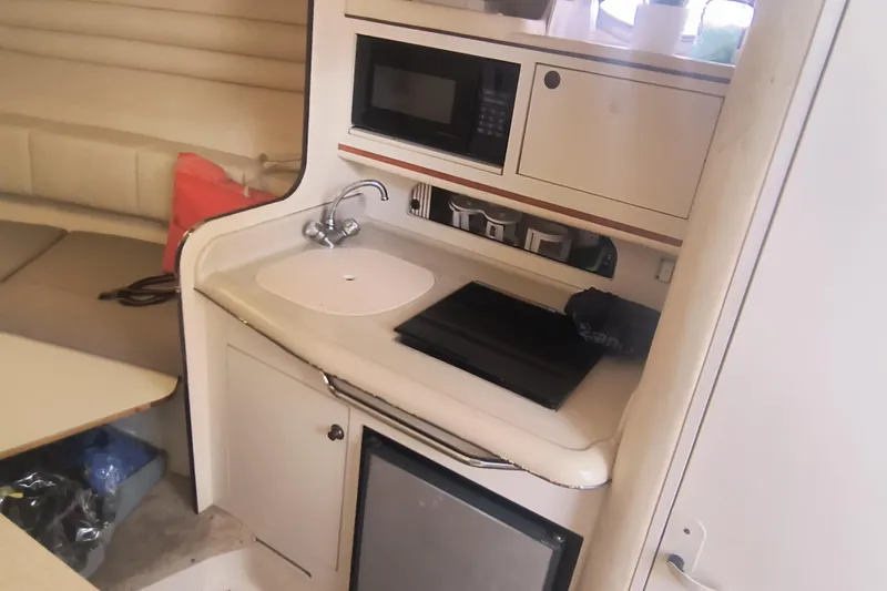 Slide: The Image of Interior of 2000 Sea Ray 270 Sundancer with kitchenette, sink, and seating area. - 11