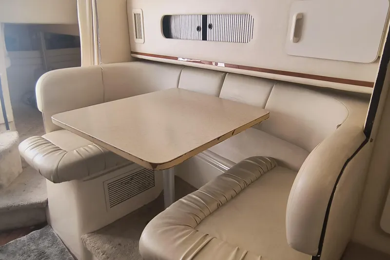 Slide: The Image of Interior of 2000 Sea Ray 270 Sundancer with cozy dining area and cushioned seating. - 12
