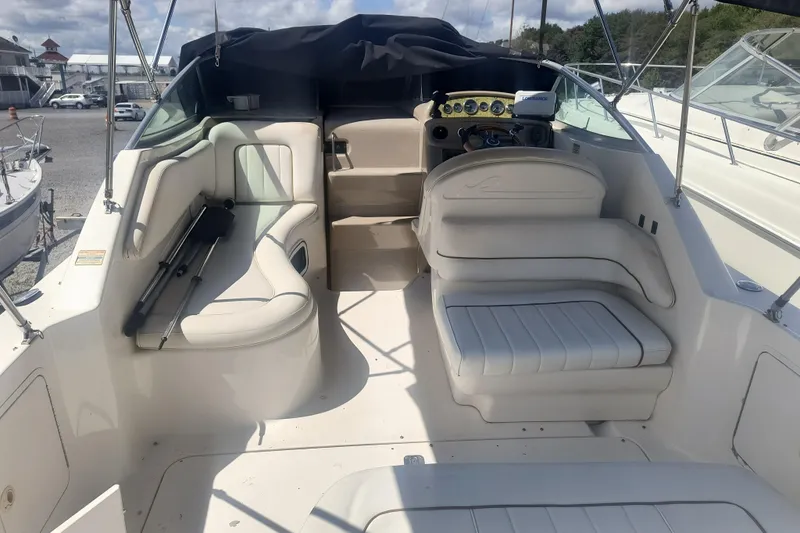 Slide: The Image of 2000 Sea Ray 270 Sundancer boat interior with white seating and steering console. - 7