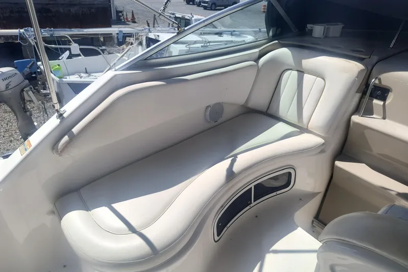 Slide: The Image of Interior seating of a 2000 Sea Ray 270 Sundancer boat, featuring white upholstery. - 9