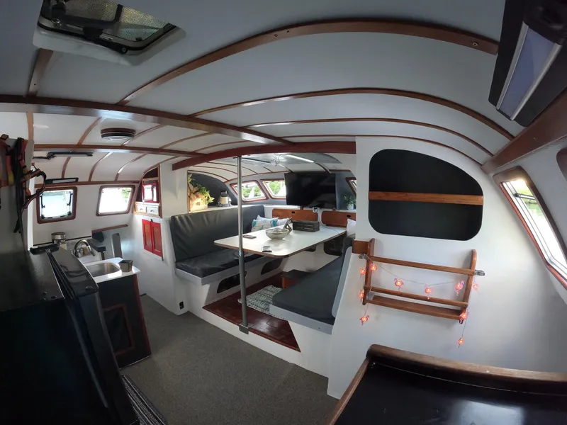 Slide: The Image of Interior of a 1972 Custom 53 Catamaran with cozy seating and dining area. - 10