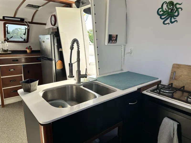 Slide: The Image of Interior of a 1972 Custom 53 Catamaran kitchen with modern appliances and nautical decor. - 13
