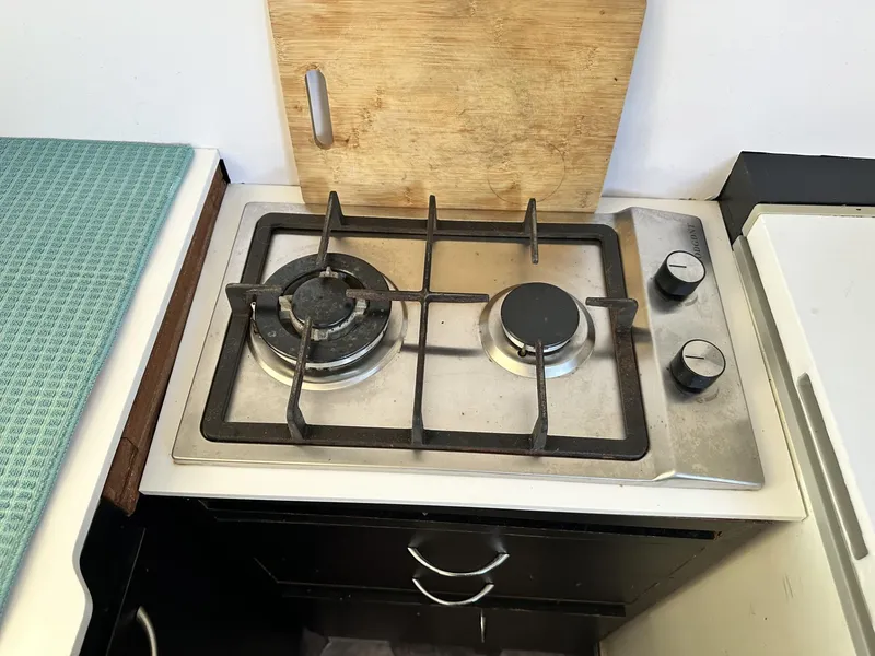 Slide: The Image of Two-burner stove on a 1972 Custom 53 Catamaran with wooden cutting board. - 17