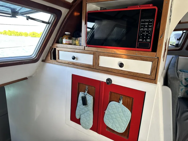 Slide: The Image of Interior of a 1972 Custom 53 Catamaran with microwave and storage cabinets. - 18