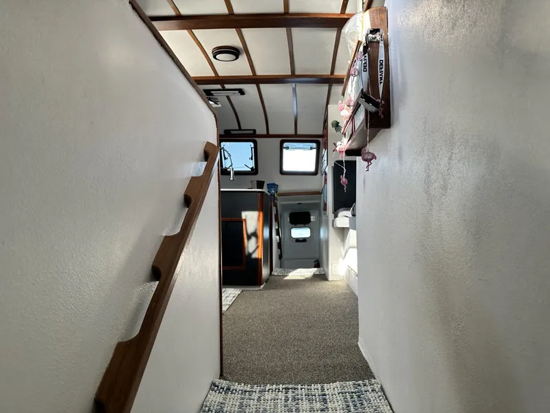 Slide: The Image of Interior hallway of a 1972 Custom 53 Catamaran with wooden accents and carpeted floor. - 19