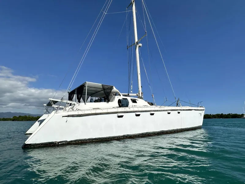 Slide: The Image of 1972 Custom 53 Catamaran sailing on clear blue water under a sunny sky. - 2