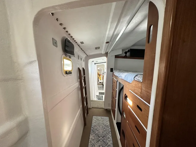 Slide: The Image of Interior of a 1972 Custom 53 Catamaran, featuring wooden cabinetry and cozy sleeping quarters. - 22