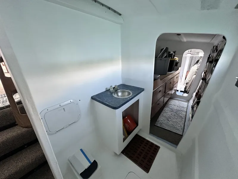 Slide: The Image of Interior of a 1972 Custom 53 Catamaran featuring a compact sink and storage area. - 29