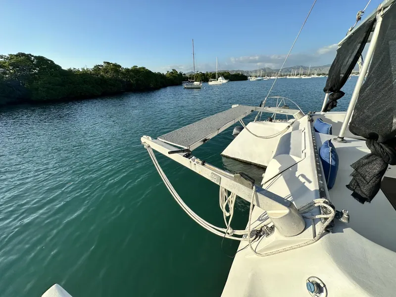 Slide: The Image of 1972 Custom 53 Catamaran on calm water, surrounded by lush greenery and distant boats. - 38