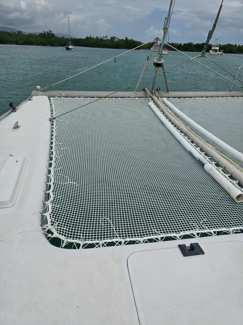 Slide: The Image of 1972 Custom 53 Catamaran with netting, anchored in serene waters. - 41