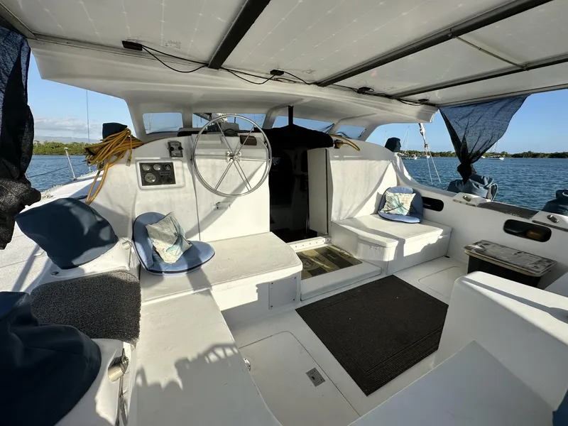 Slide: The Image of Interior of a 1972 Custom 53 Catamaran with seating and steering wheel, overlooking the water. - 5