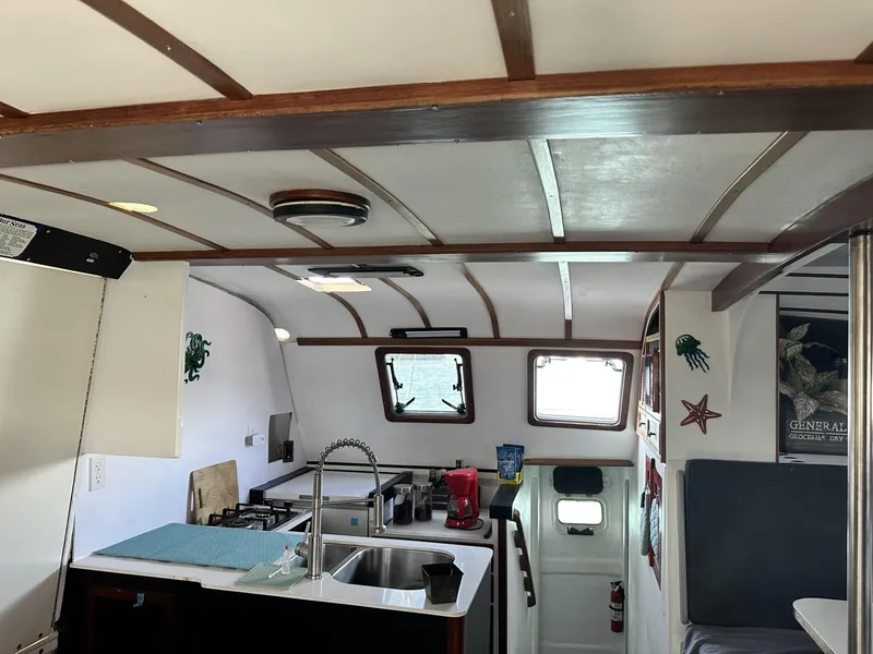 Slide: The Image of Interior of a 1972 Custom 53 Catamaran with kitchen and seating area. - 9
