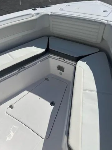 Slide: The Image of 2024 Edgewater 340CC boat interior with cushioned seating and storage compartments. - 10