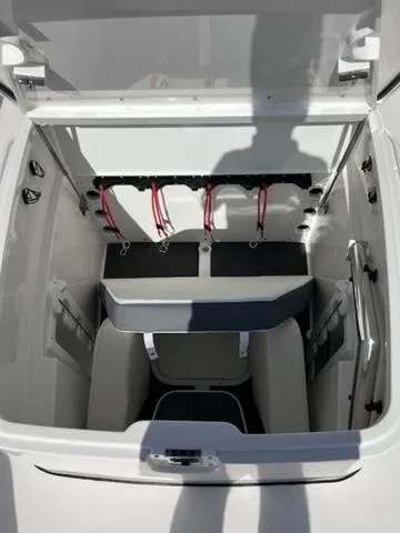 Slide: The Image of 2024 Edgewater 340CC boat storage compartment with open lid, showcasing interior design and features. - 12