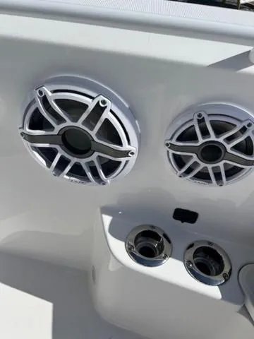 Slide: The Image of 2024 Edgewater 340CC boat speakers and cup holders in sleek white design. - 13