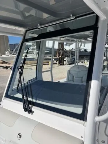 Slide: The Image of 2024 Edgewater 340CC boat windshield with wipers, docked in a marina. - 14