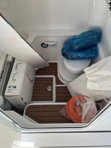 Slide: The Image of 2024 Edgewater 340CC boat interior with storage items and marine toilet. - 15