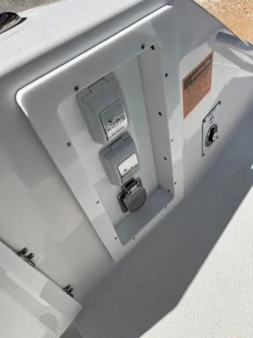 Slide: The Image of 2024 Edgewater 340CC boat control panel with switches and outlets. - 23