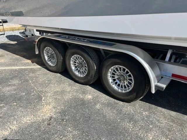 Slide: The Image of 2024 Edgewater 340CC boat on a triple-axle trailer, parked on asphalt. - 26
