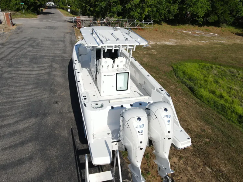 Slide: The Image of 2024 Edgewater 340CC boat with twin engines on a trailer, parked outdoors. - 3