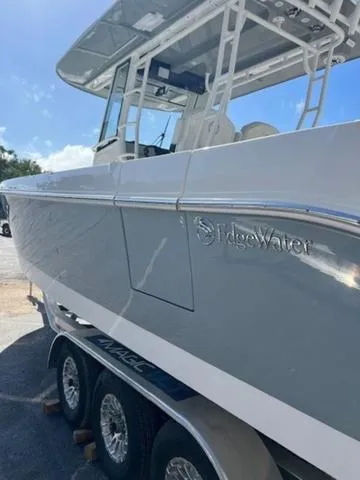 Slide: The Image of 2024 Edgewater 340CC boat on trailer, side view under clear blue sky. - 30