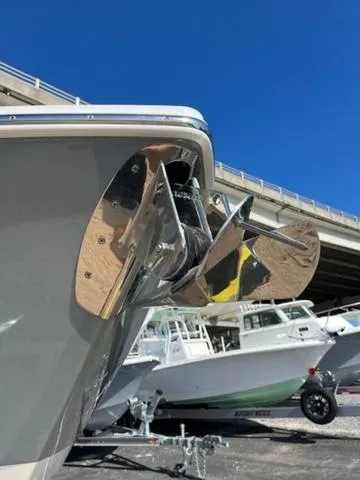 Slide: The Image of 2024 Edgewater 340CC boat anchor detail with other boats in background under clear blue sky. - 31