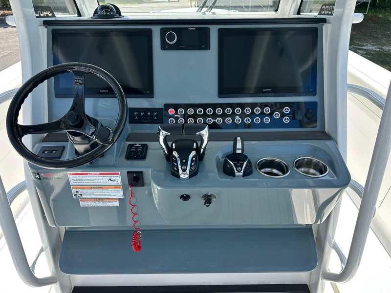 Slide: The Image of 2024 Edgewater 340CC boat dashboard with dual screens, steering wheel, and control panel. - 6