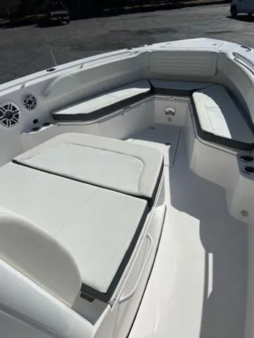 Slide: The Image of 2024 Edgewater 340CC boat interior with white cushioned seating and modern design. - 9