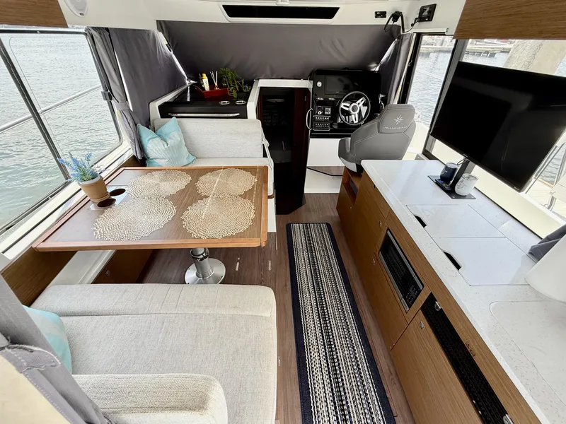 Slide: The Image of Interior of 2022 Jeanneau NC 1095 Coupe with modern seating and navigation area. - 12