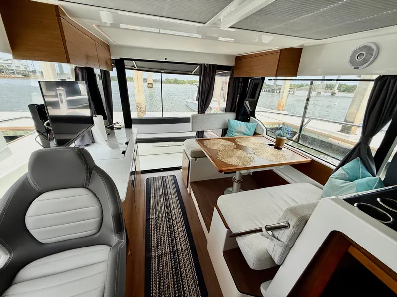 Slide: The Image of Interior of 2022 Jeanneau NC 1095 Coupe with modern seating and dining area. - 13