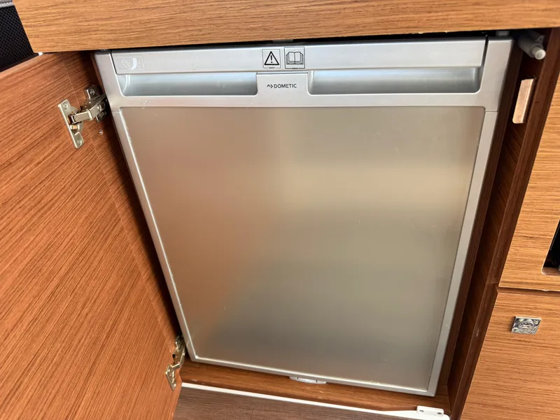 Slide: The Image of Built-in fridge on 2022 Jeanneau NC 1095 Coupe boat, wooden cabinetry. - 16