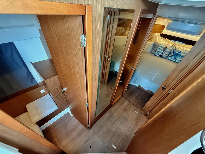 Slide: The Image of Interior of 2022 Jeanneau NC 1095 Coupe, featuring wood finishes and cozy cabin space. - 21