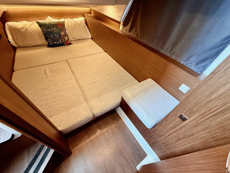 Slide: The Image of 2022 Jeanneau NC 1095 Coupe cabin with cozy bed and wooden interior. - 24