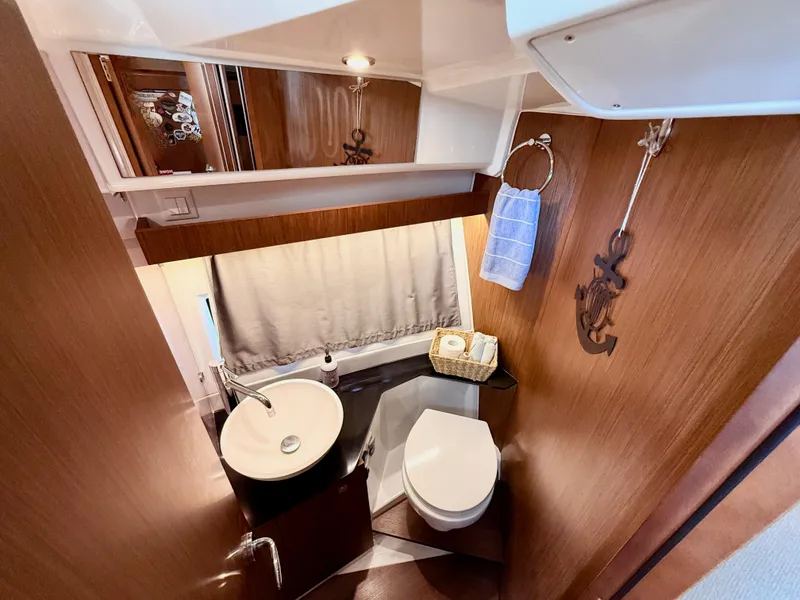 Slide: The Image of Bathroom interior of 2022 Jeanneau NC 1095 Coupe with modern fixtures and wooden accents. - 27