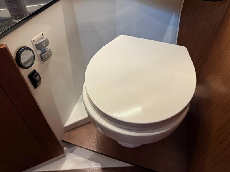 Slide: The Image of Toilet in 2022 Jeanneau NC 1095 Coupe boat, featuring modern design and wood accents. - 29