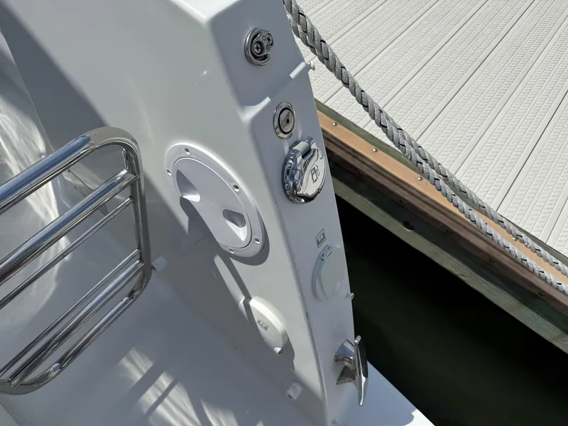 Slide: The Image of 2022 Jeanneau NC 1095 Coupe boat deck with railing and dockside view. - 7