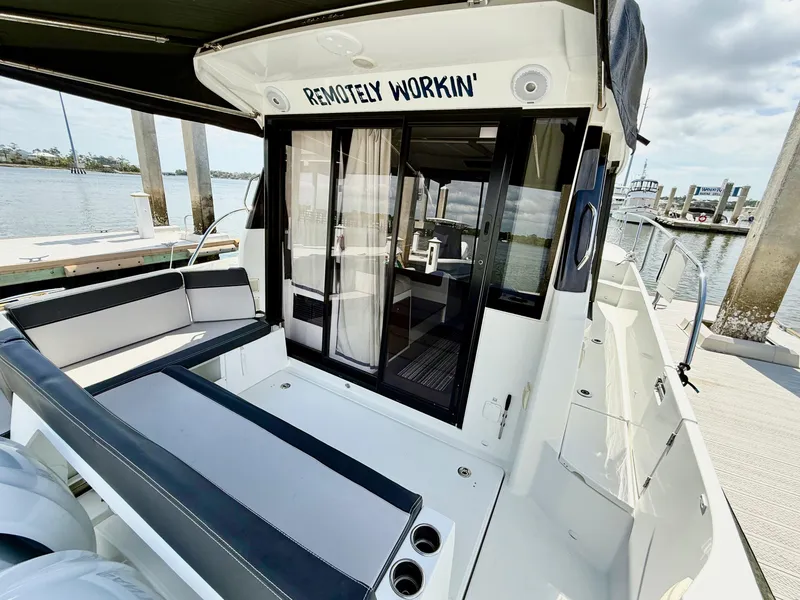 Slide: The Image of 2022 Jeanneau NC 1095 Coupe boat with seating area, docked by the water. - 8