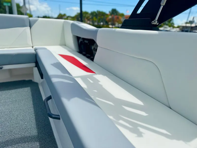 Slide: The Image of 2023 MasterCraft NXT24 boat interior with white seating and red accent. - 15