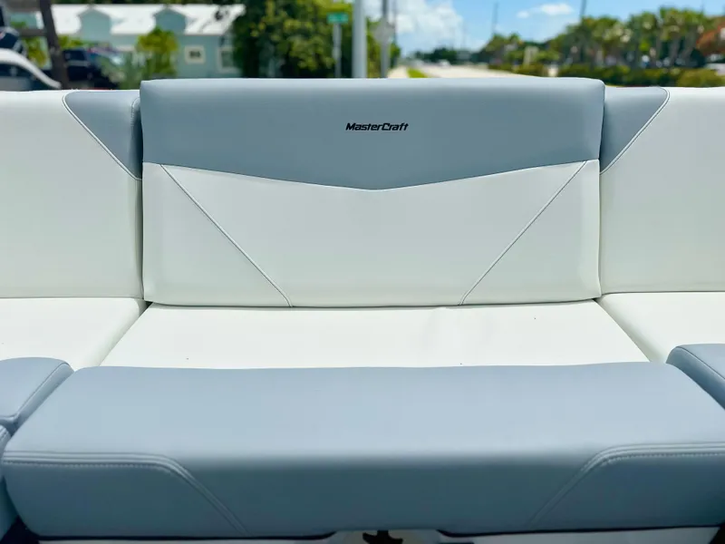 Slide: The Image of 2023 MasterCraft NXT24 boat seat with gray and white upholstery, outdoor setting. - 17