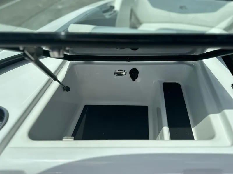 Slide: The Image of 2023 MasterCraft NXT24 boat storage compartment with open lid, showcasing interior space. - 34
