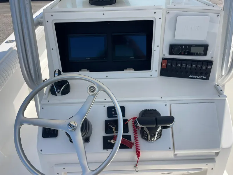 Slide: The Image of 2007 Regulator 26 Forward Seating boat dashboard with steering wheel and control panel. - 12