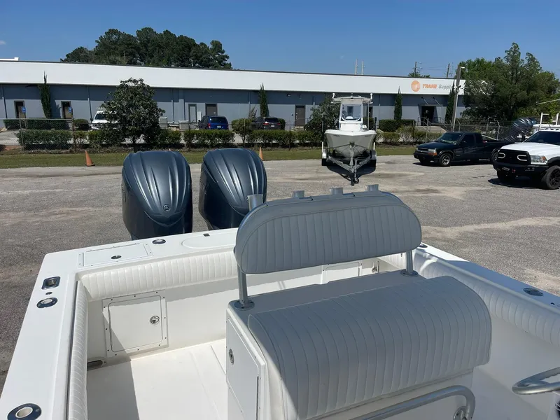 Slide: The Image of 2007 Regulator 26 Forward Seating boat with dual engines in a parking lot. - 15