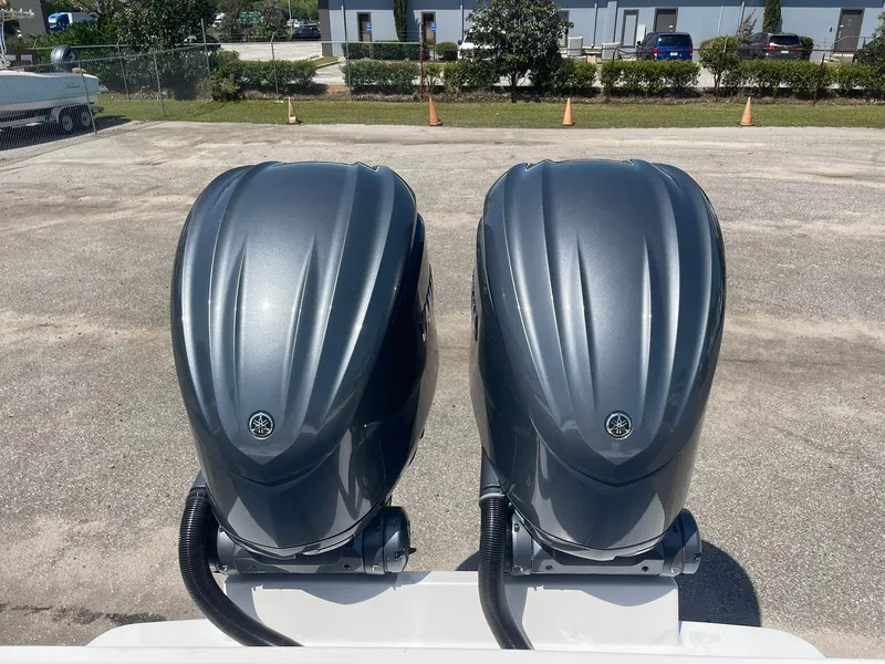 Slide: The Image of Twin outboard motors on a 2007 Regulator 26 Forward Seating boat, parked outdoors. - 23