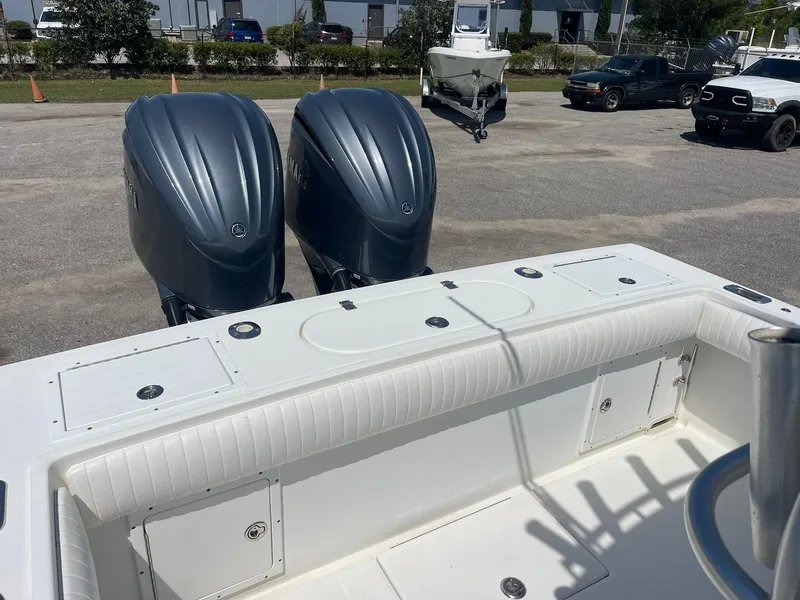 Slide: The Image of 2007 Regulator 26 Forward Seating boat with dual outboard engines in a parking area. - 24