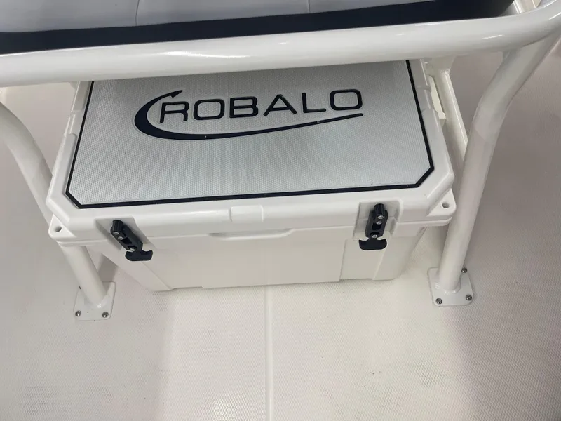 Slide: The Image of 2025 Robalo R180 Center Console boat cooler with logo, secured under seating. - 11