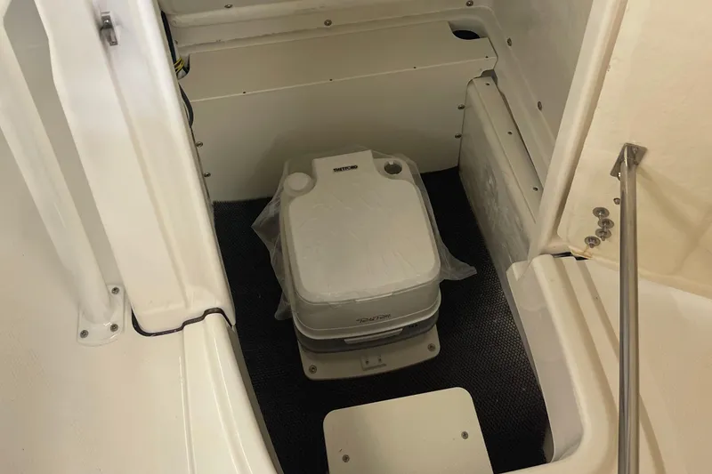 Slide: The Image of 2025 Robalo R180 Center Console boat interior with portable toilet. - 5